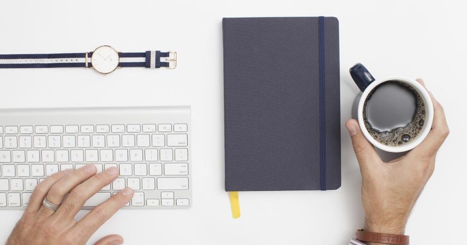 How to Clean Your Email List: A Simple Hygiene Routine Hands using a keyboard beside a notebook and a cup of coffee on a white desk